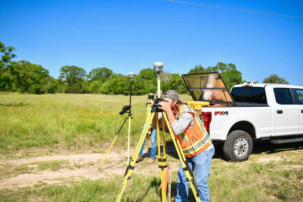 Land survey technician peers into visual port of Total Robotic Station for Landesign Services, Inc.